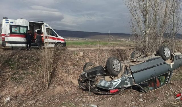 Takla atan aracın altında kalan sürücü yaralı kurtuldu