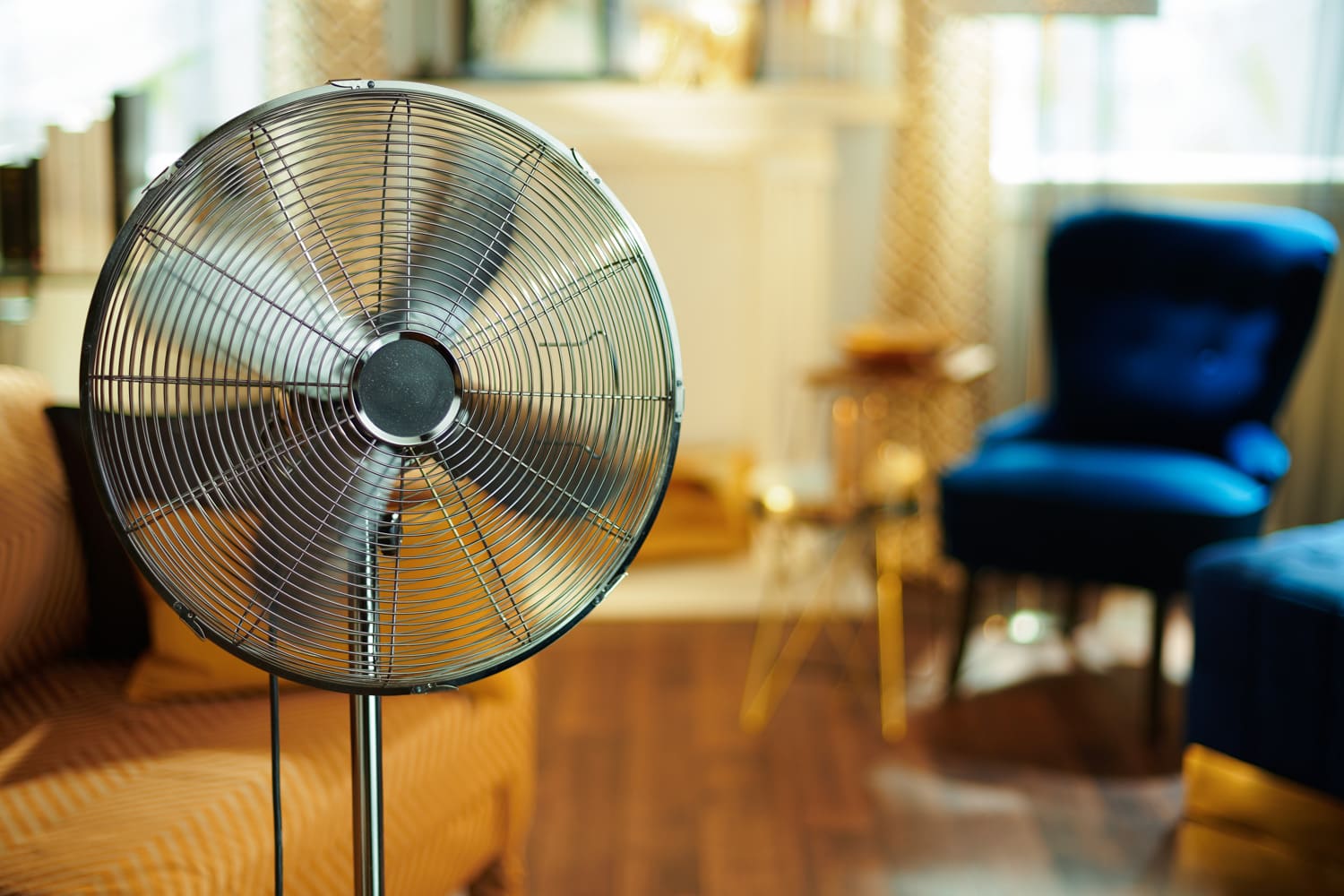Closeup-on-working-electric-floor-standing-fan-in-the-modern-house-in-sunny-hot-summer-day.